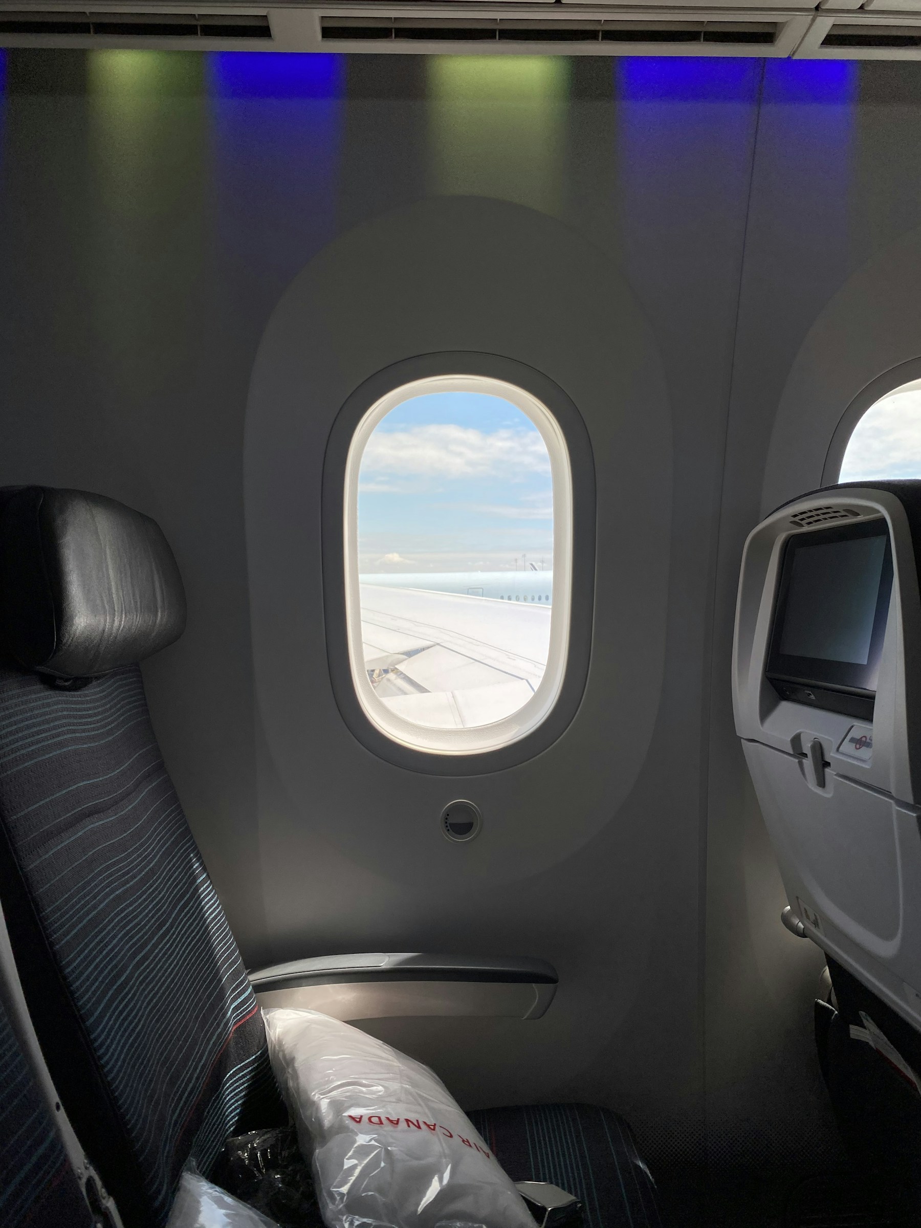 Veľké okno v kabíne lietadla Boeing 787 Dreamliner a obrazovka sedadla